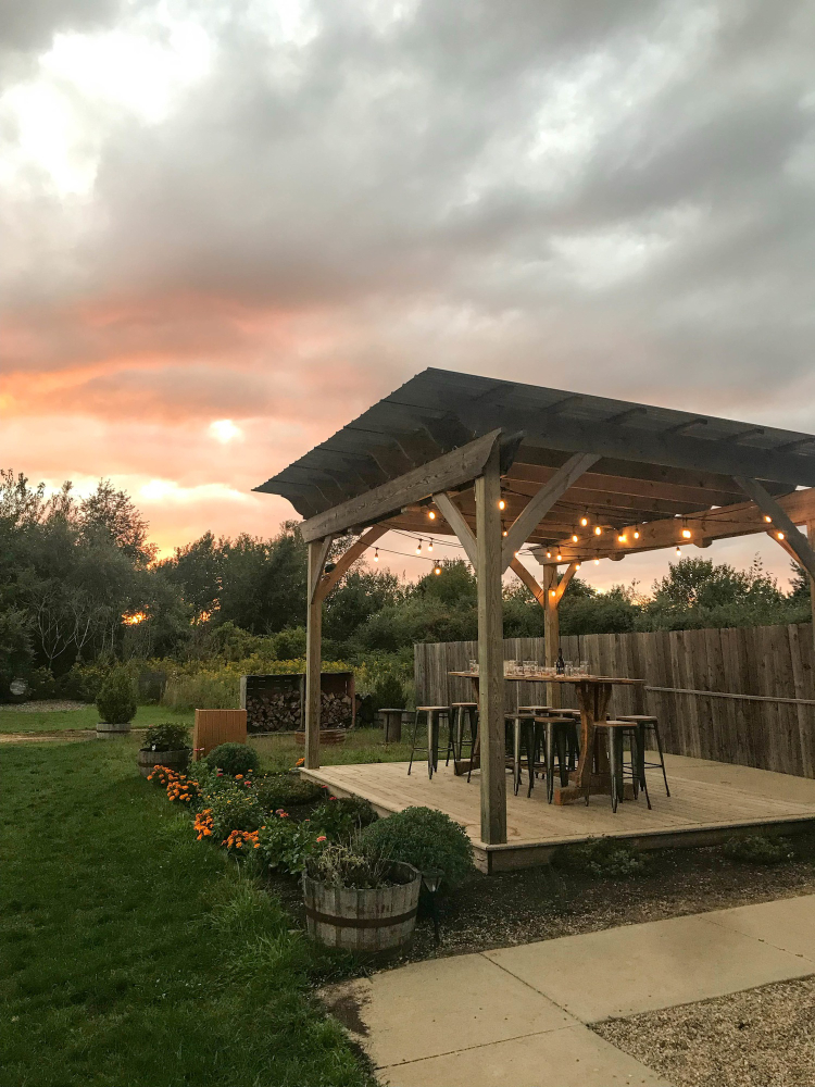 Gazebo oświetlone lampkami podczas zachodu słońca, tworzące romantyczną atmosferę.